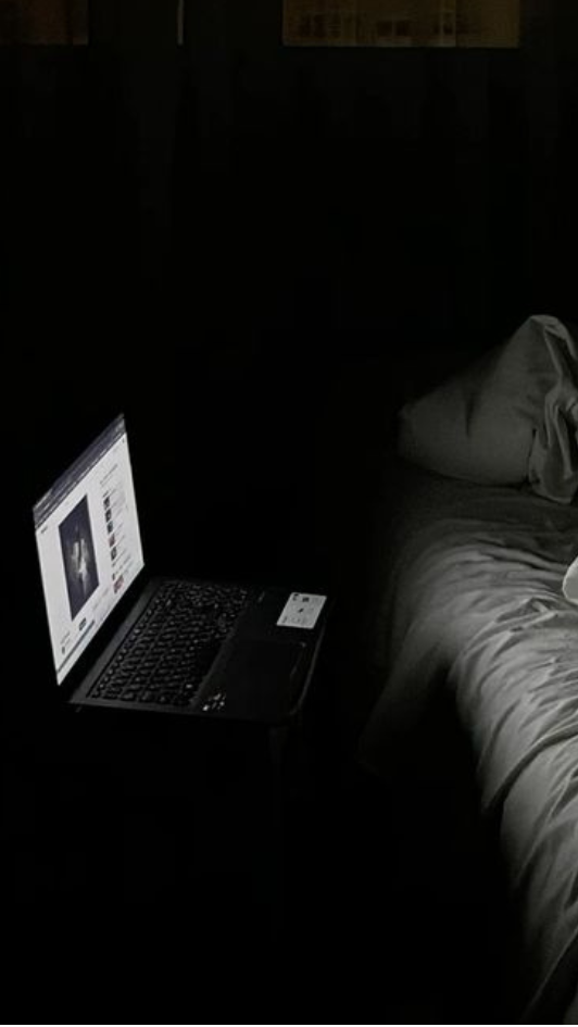 Dunkles Schlafzimmer mit leuchtendem Laptop, Einschlafvideo läuft